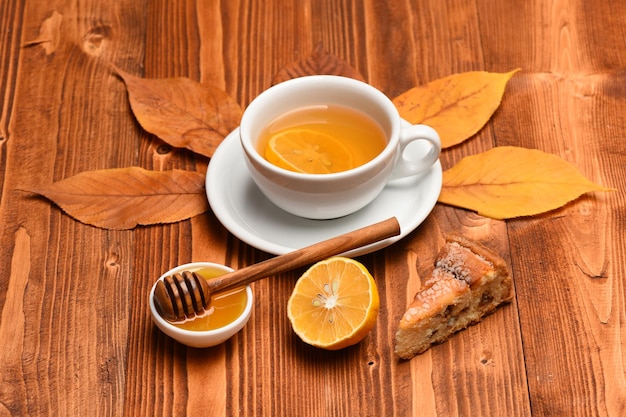 Cup of green tea with tea bag put on beautiful leaves Autumn beauty and drink concept