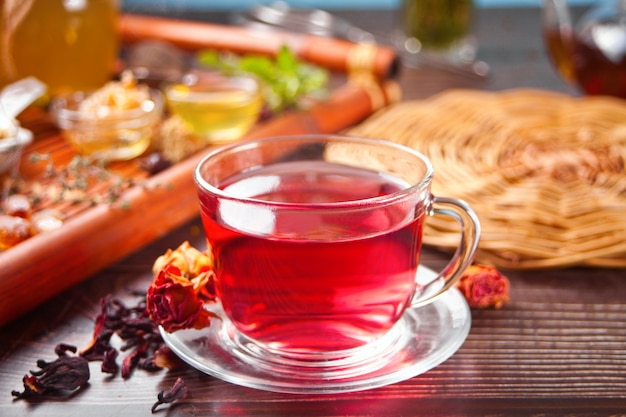 Cup of herbal red tea with dry roses hibiscus