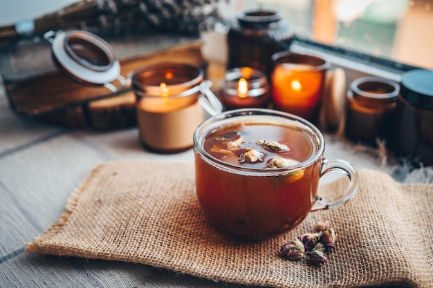 A cup of herbal tea with burning candles aesthetically warm photo