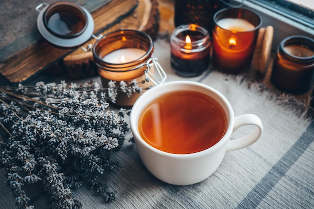 A cup of herbal tea with burning candles aesthetically warm photo