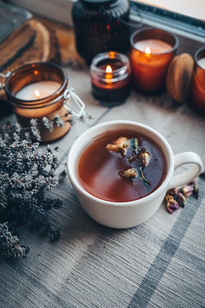 A cup of herbal tea with burning candles aesthetically warm photo