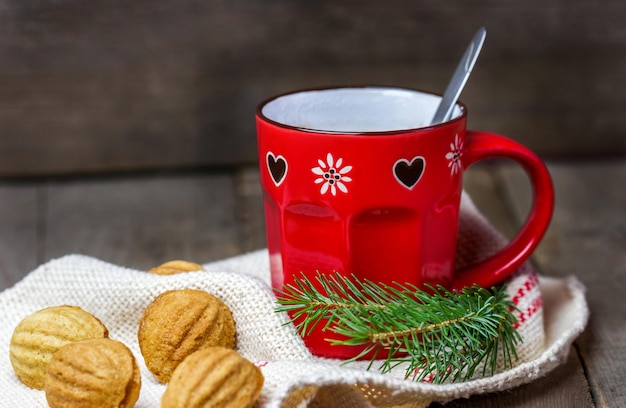 Cup of hot chocolate with christmas tree branches and cookies on the table