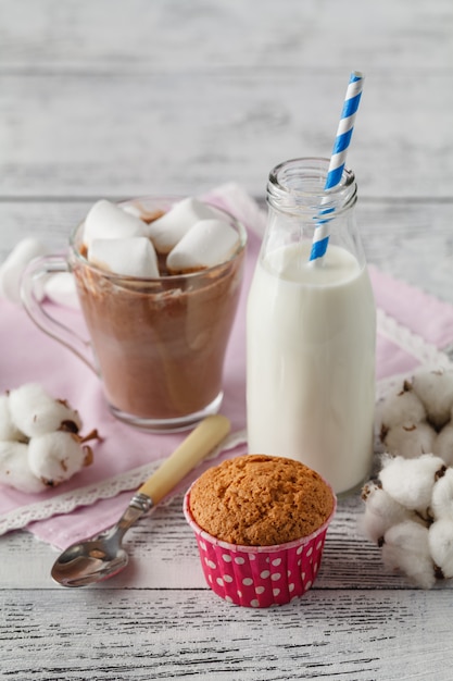 cup of hot chocolate with cinnamon and marshmallows on wooden table