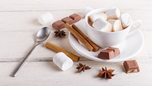 A cup of hot chocolate with marshmallow and spices