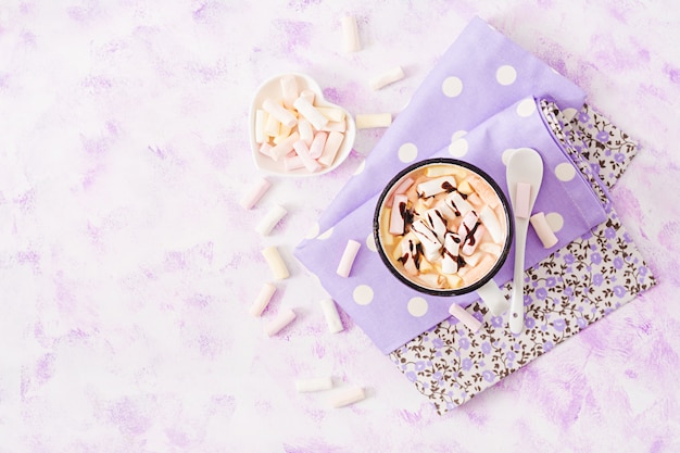 Cup of hot cocoa or chocolate with marshmallow on a light table