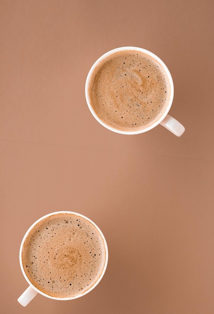 Cup of hot coffee as breakfast drink flatlay cups on beige background