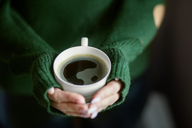 A cup of hot coffee in the hands Concept drinks lifestyle work background