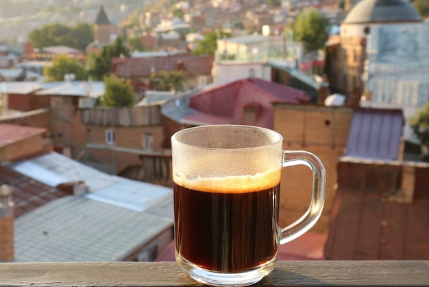 Cup of Hot Coffee at the Terrace with Blurry City View in the Backdrop