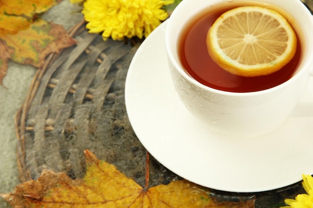 Cup of hot drink and autumn leaves close up