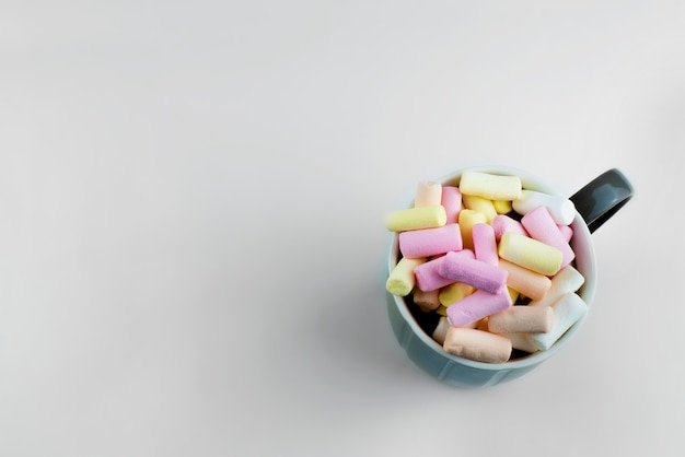 the cup is photographed from above. Multicolored marshmallows in a cup