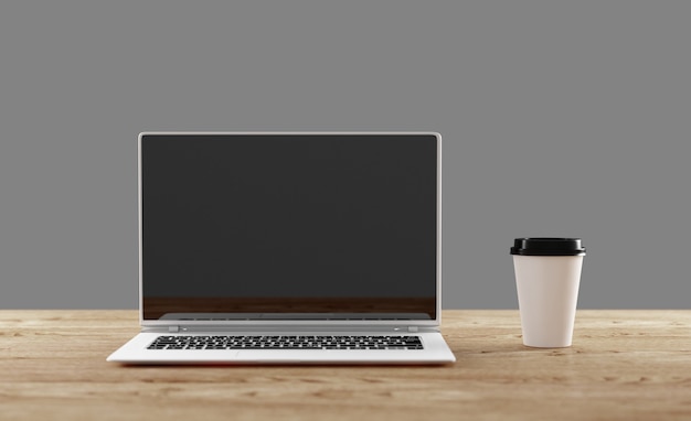 cup and laptop on a table in an office