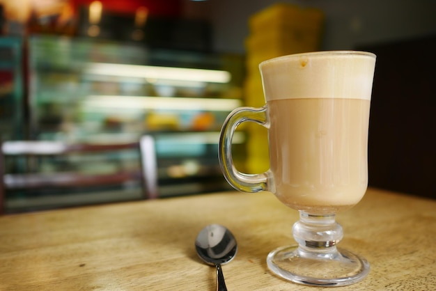 A cup of late coffee and spoon on cafe table