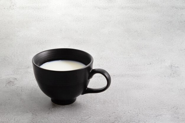 Cup of milk black cup on cement surface