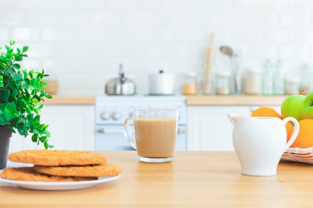 Cup of morning coffee, cookies and fruit on the kitchen table. Good morning or breakfast concept.