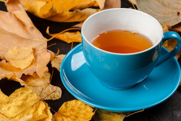 Cup of tea and autumn leaves on the table