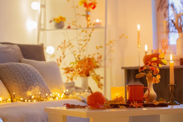 cup of tea and autumnal leaves in cozy interior