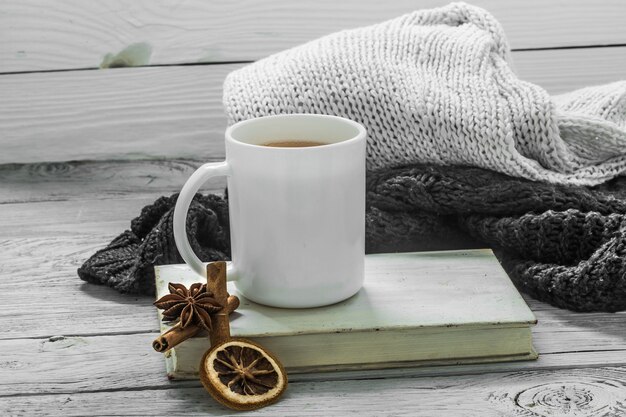 the Cup of tea on a beautiful wooden background with winter sweater, old book , winter ,autumn, close-up