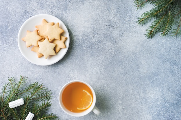 Cup of tea and cookies, pine branches, cinnamon sticks, anise stars