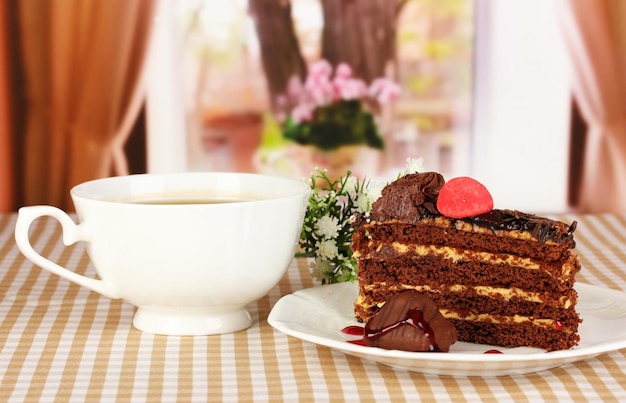 Cup of tea and delicious cake on window background