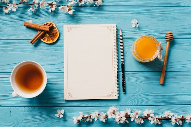 cup of tea and honey on blue wooden background