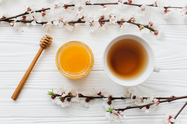 cup of tea and honey on wooden background