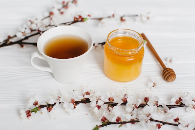 cup of tea and honey on wooden background