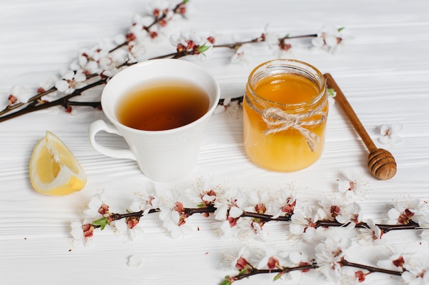 cup of tea and honey on wooden background