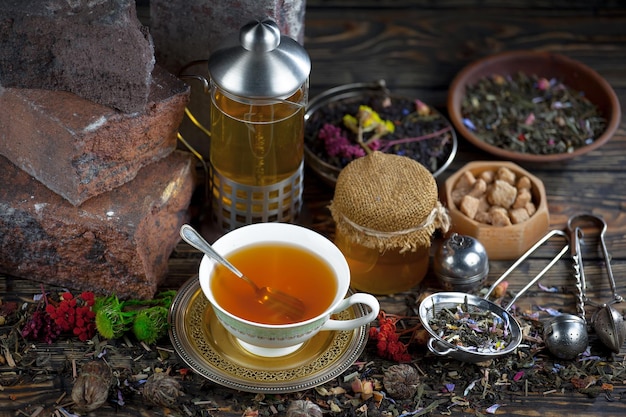 A cup of tea sits on a table next to a jar of tea.