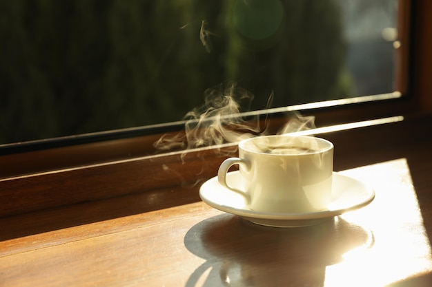 Cup of tea stands on wooden windowsill