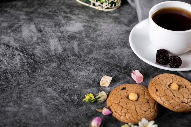 A cup of tea with almond cookies on the marble