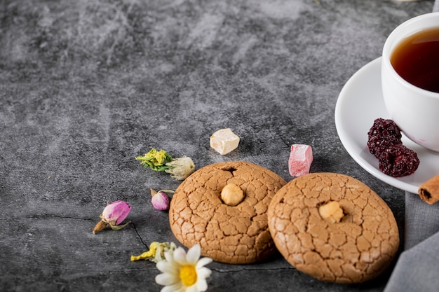 Photo a cup of tea with almond cookies