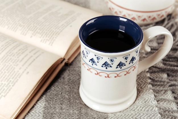 Cup of tea with book on table close-up