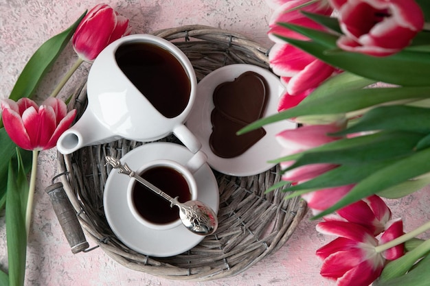 Cup of tea with chocolate and tulips