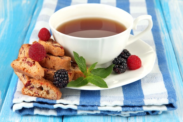 Cup of tea with cookies and berries on table closeup