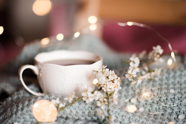 Cup of tea with flowers closeup. SPring season. Cozy atmosphere.