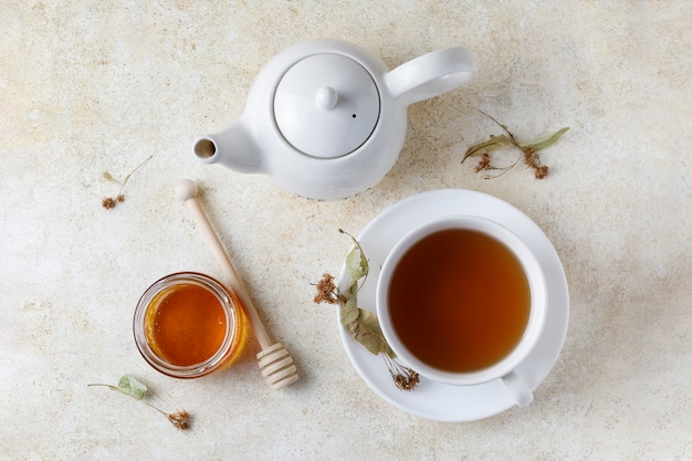 Cup of of tea with honey and teapot