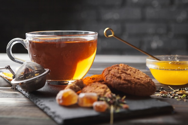 Cup of tea with lemon and honey on wooden .