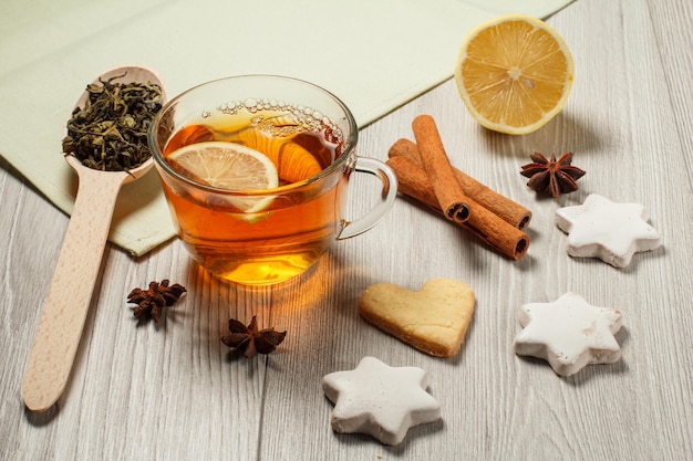 Cup of tea with slice of lemon gingerbread cookies in star and cinnamon