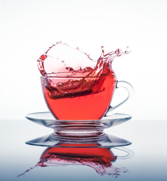 Cup of tea with splashes on the mirror surface