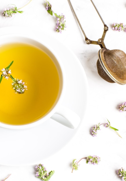 A Cup of tea with thyme flowers on a white background. The view from the top. Concept of folk medicine.