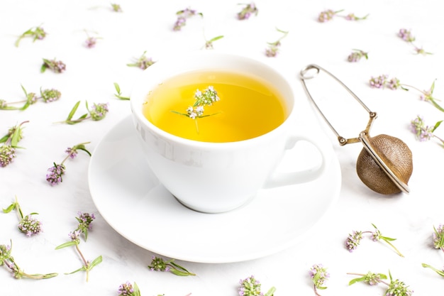 A Cup of tea with thyme flowers on a white background. The view from the top. Concept of folk medicine.