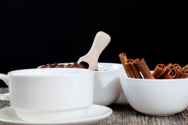 A cup with cinnamon spices and coffee beans