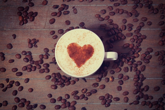 Photo cup with coffee and shape of the cacao heart on it.