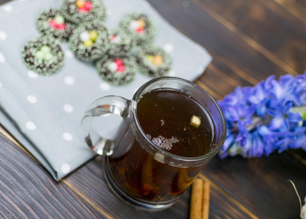 A cup with herbal tea and cookies on a dark background