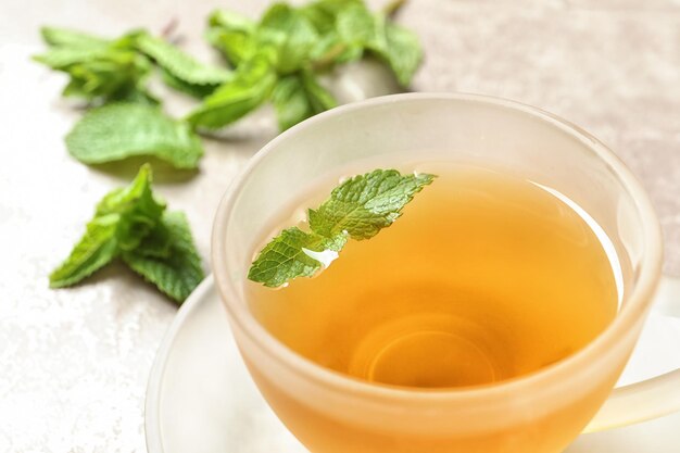 Cup with hot aromatic mint tea closeup