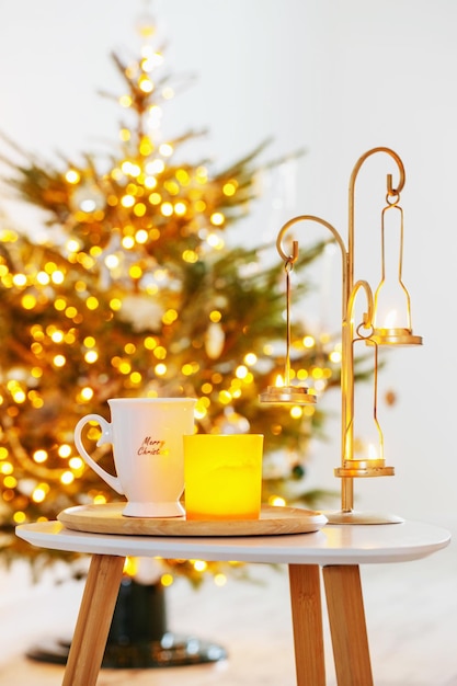 Cup with hot drink on background christmas tree