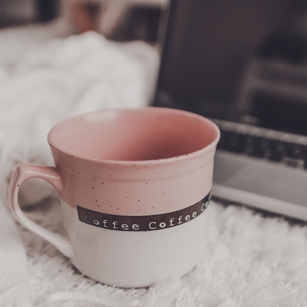 Cup with laptop in room