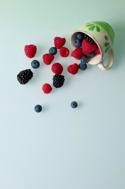 Photo cup with red fruits on green background