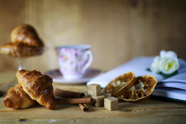 Cup with tea croissant book