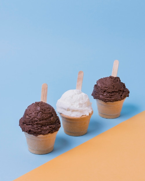 Cup with vanilla and chocolate ice cream on table